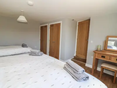 a bedroom with a large bed with towels on it at Curtau in Builth Wells