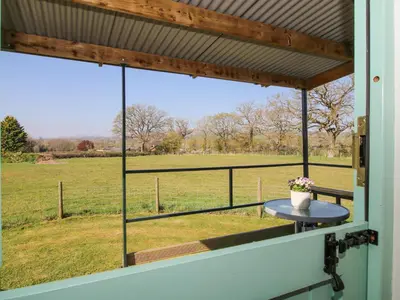 a view of a field from the window of a house at Gilberry Shepherds Hut in Church Stretton