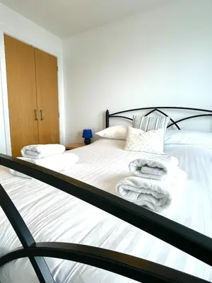 a bedroom with a bed with towels on it at Duplex apartment with spectacular sea views! in Aberystwyth