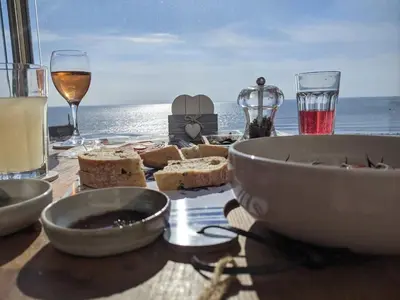 a table with a bowl of bread and glasses of wine at Duplex apartment with spectacular sea views! in Aberystwyth