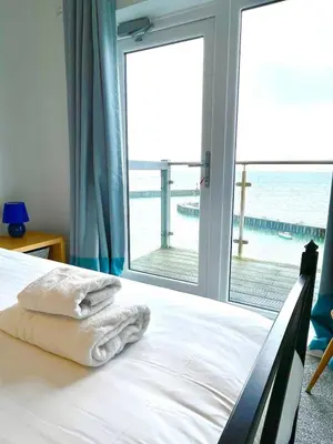 a bedroom with a bed with a view of the ocean at Duplex apartment with spectacular sea views! in Aberystwyth