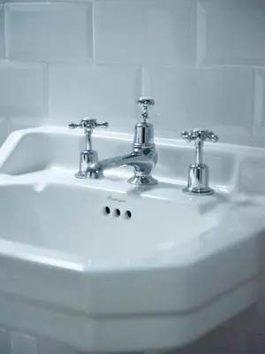 a white bathroom sink with two faucets on it at The Bryntirion Inn in Llandderfel
