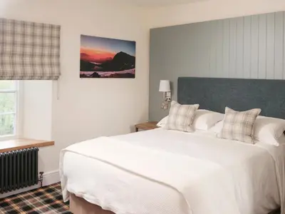 a bedroom with a large white bed and a window at The Bryntirion Inn in Llandderfel