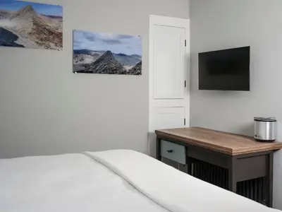 a bedroom with a bed and a desk and a television at The Bryntirion Inn in Llandderfel