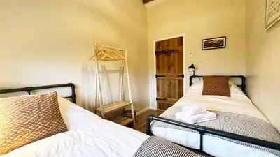 a bedroom with two beds and a mirror in it at Peaceful Dyfi Valley Cottage - Hendre-gau in Machynlleth