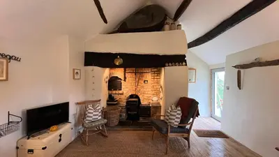 a living room with a fireplace and a tv at Peaceful Dyfi Valley Cottage - Hendre-gau in Machynlleth