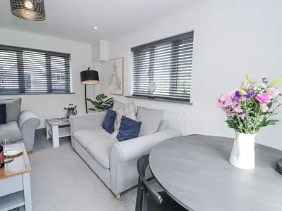 a living room with a couch and a table with flowers at The Coach House in Dolgellau