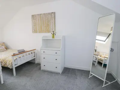 a bedroom with a white dresser and a mirror at The Coach House in Dolgellau