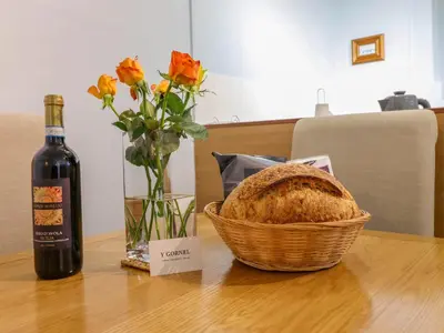 a bottle of wine and a basket of bread on a table at Beach Haven in Aberystwyth