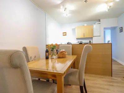a dining room and kitchen with a wooden table and chairs at Beach Haven in Aberystwyth