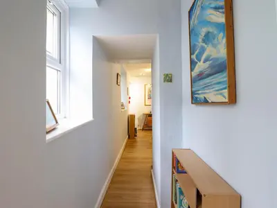 a hallway with a staircase with a painting on the wall at Beach Haven in Aberystwyth