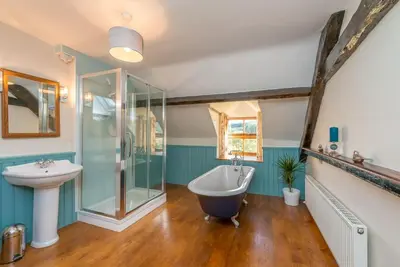 a bathroom with a bath tub and a sink at Ty-Mawr in Llanuwchllyn