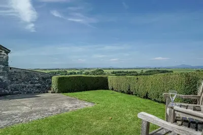 a garden with a bench and a hedge at Gegin-Faeldre in Llanbedr