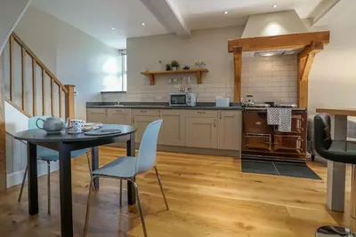 a kitchen with a table and chairs in a room at Gegin-Faeldre in Llanbedr