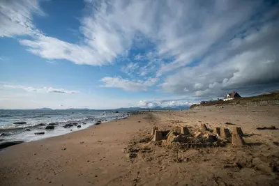 a sand castle on a beach near the ocean at Gegin-Faeldre in Llanbedr