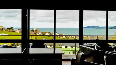 a room with a view of the ocean through a window at Coastal Bliss Charming Cottage near Borth beach in Borth