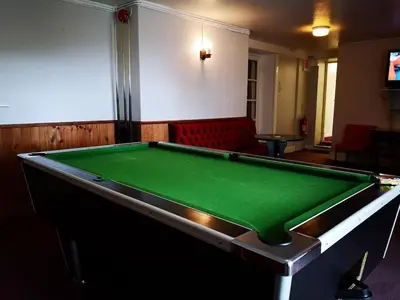 a green pool table in a room with aroup of chairs at Family-Friendly Woodland Caravan Pool & Bar in Bryn-glâs Station
