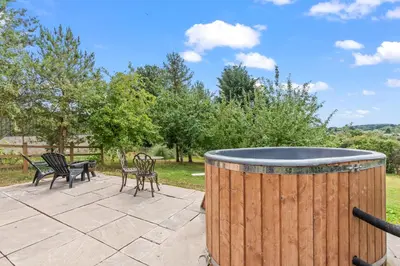 a barrel on a patio with chairs and a table at Off-Grid Glamping - Quiet, Starry Escape in Yarpole