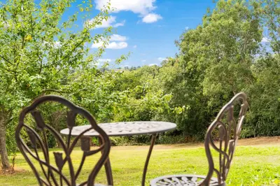 a table and two chairs sitting in the grass at Off-Grid Glamping - Quiet, Starry Escape in Yarpole
