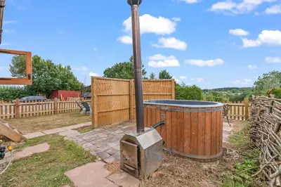 a wood stove in a yard with a fence at Unplug & Reconnect, Romantic Retreat with Hot Tub in Yarpole