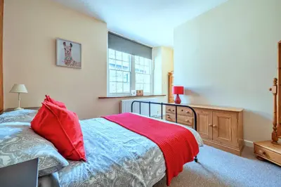 a bedroom with a bed with a red blanket on it at Finest Retreats - Yr Daflod in Brecon