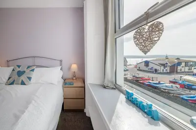 a bedroom with a window with a view of a marina at Aberdyfi Sea View Apartment in Aberdyfi