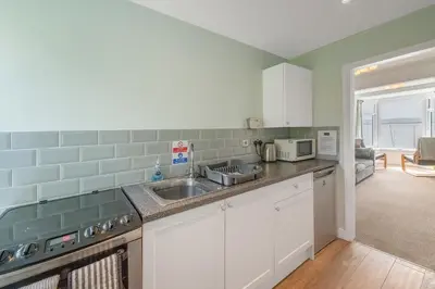 a kitchen with a sink and a microwave at Aberdyfi Sea View Apartment in Aberdyfi