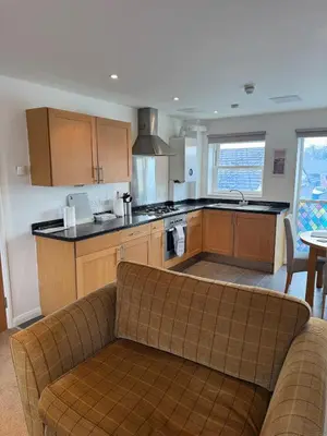 a living room with a couch and a kitchen at Modern, sleeps 6, rural market town, Llani in Llanidloes