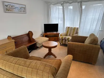 a living room with a couch and chairs and a tv at Modern, sleeps 6, rural market town, Llani in Llanidloes