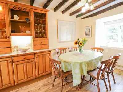 a kitchen with a table with a vase of flowers on it at Ty Glan Yr Afon in Dolgellau