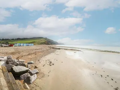 a beach with a rock wall and the ocean at Ty Glan Yr Afon in Dolgellau