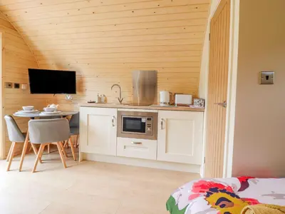 a room with a kitchen and a table with a microwave at Briallen in Dolgellau