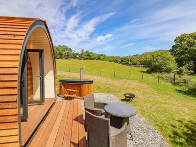 a deck with a grill and a table and chairs at Briallen in Dolgellau