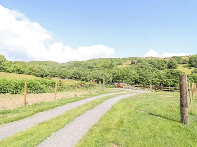 a dirt road in a field with a fence at Eirlys in Dolgellau