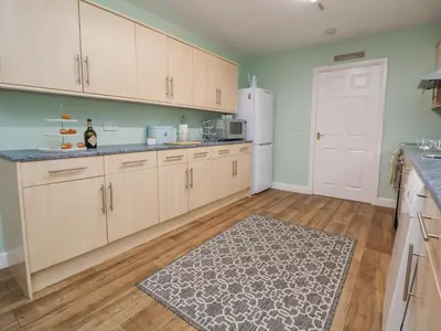 a kitchen with wooden cabinets and a white refrigerator at 2 Mountain View in Wrexham