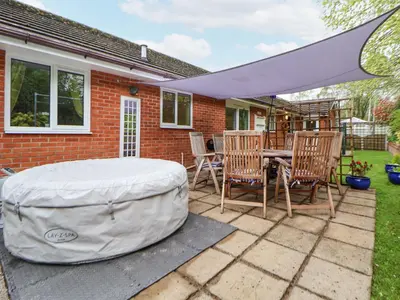 a patio with a table and chairs and a large umbrella at 2 Mountain View in Wrexham