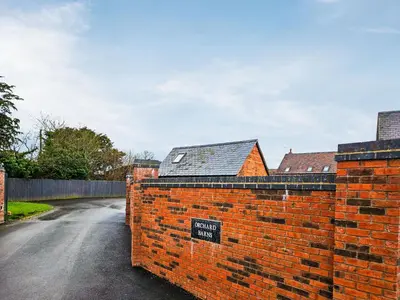 a brick wall with a sign on the side of a street at The Little House - Uk49129 in Stapleton