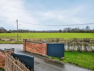 a brick gate on a road next to a field at The Little House - Uk49129 in Stapleton