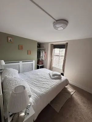 a bedroom with a large bed and a window at The Cottage on the Rock in Barmouth