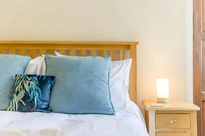 a bed with blue pillows and a candle on a night stand at 2 Bed in Ludlow oc-d31885 in Ludlow