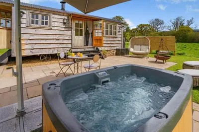 a hot tub on a patio next to a cabin at 1 Bed in Brecon oc-t31948 in Bronllys