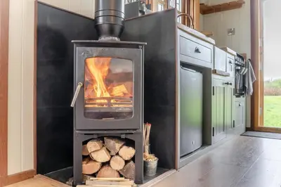 a wood stove in a kitchen with logs at 1 Bed in Brecon oc-t31948 in Bronllys