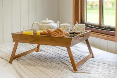 a wooden tray with pastries and orange juice on a bed at 1 Bed in Bronllys oc-t31949 in Bronllys