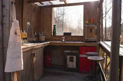 a kitchen with a counter and a sink and a window at The Charcoal Hut woodland retreat in Llandovery