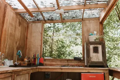 an outdoor kitchen with a window and a sink at The Charcoal Hut woodland retreat in Llandovery