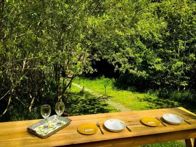 a wooden table with plates and wine glasses on it at The Charcoal Hut woodland retreat in Llandovery