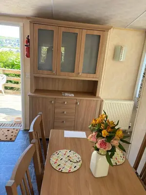 a table in a kitchen with a vase of flowers on it at The Panorama View Luxury Retreat in Aberystwyth in Aberystwyth