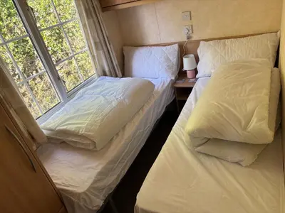 two beds in a small room with two windows at The Panorama View Luxury Retreat in Aberystwyth in Aberystwyth