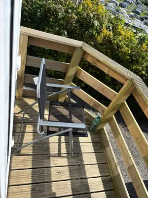 a chair on a wooden deck with a bench at The Panorama View Luxury Retreat in Aberystwyth in Aberystwyth