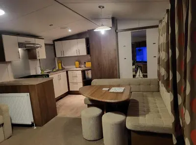 a kitchen with a table and a couch in a room at River View Modern 3 Bedroom Pet Friendly in Clarach Bay in Aberystwyth